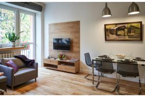 华沙Kredytowa Warsaw Apartment的客厅配有桌子、沙发和电视