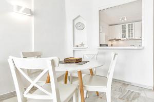 阿德耶Apartamento Altamira的白色的用餐室配有白色的桌椅