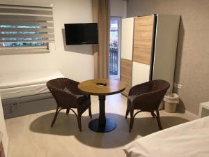 克雷姆林根温伯格酒店的配有桌子和两把椅子及一张床的房间
