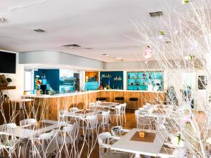 马略卡岛帕尔马利斯马洛卡酒店的一间设有白色桌子和白色椅子的餐厅