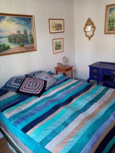 KasköFoggy Island B&B的一间卧室配有一张带蓝色条纹毯子的床