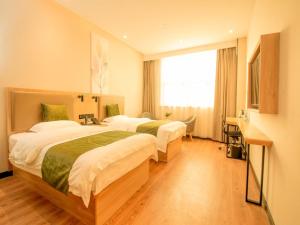 南京GreenTree Inn Nanjing Lukou Airport的酒店客房设有两张床和窗户。