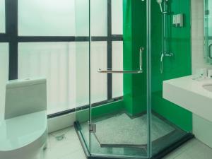 桂林格林豪泰桂林临桂区麓湖国际快捷酒店的一间带玻璃淋浴和卫生间的浴室