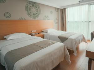 桂林格林豪泰桂林临桂区麓湖国际快捷酒店的酒店客房设有两张床和窗户。