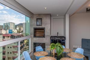 伊塔佩马Nilmare Apartamentos e Suites para suas Férias的设有带桌椅的市景阳台。