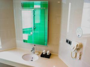 淮安格林豪泰淮安翔宇北道长江东路快捷酒店的一间带水槽和绿色镜子的浴室