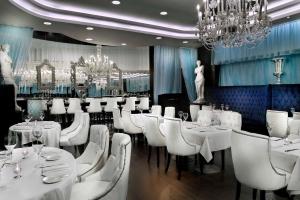 开罗Sun City Hotel - The Gabriel的用餐室配有白色的桌子和白色的椅子