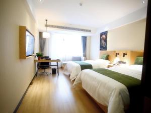 阜阳格林豪泰阜阳市会展中心商务酒店的酒店客房配有两张床和一张书桌