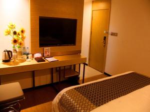 南京格林豪泰南京市省人民医院智选酒店的酒店客房配有一张书桌、一台电视和一张床
