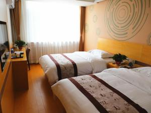 沈阳格林豪泰沈阳盛京医院滑翔地铁站商务酒店的酒店客房设有两张床和窗户。