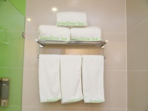 延庆县格林豪泰北京市延庆区八达岭长城康庄智选酒店的浴室内架上的一组毛巾