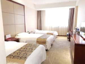 徐州格盟徐州鼓楼区三环北路金驹物流园酒店的酒店客房设有三张床和窗户。