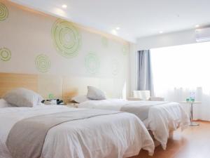 淮安格林豪泰淮安翔宇北道长江东路快捷酒店的一间卧室设有三张床、白色床单和窗户