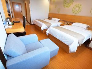 咸宁格林豪泰咸宁市高铁北站五金机电市场商务酒店的酒店客房,设有两张床和一张沙发