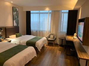 霍山格林豪泰安徽省六安市霍山县迎驾大道商务酒店的酒店客房设有两张床和一台平面电视。