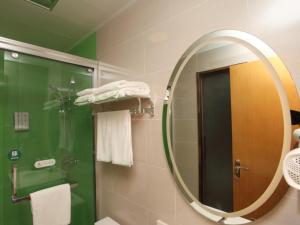合肥格林豪泰合肥淮南路淮合花园快捷酒店的浴室设有镜子、淋浴和毛巾