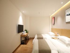 新郑贝壳郑州国际机场华夏大道酒店的酒店客房设有两张床和电视。