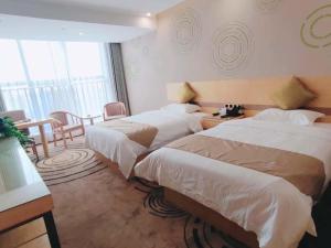 Sanhe格林豪泰淮南市山南新区二中商务酒店的酒店客房设有两张床和一张桌子。