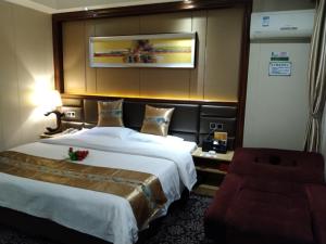 信阳格林联盟信阳平桥区南京路东阳酒店的酒店客房带一张大床和一把椅子