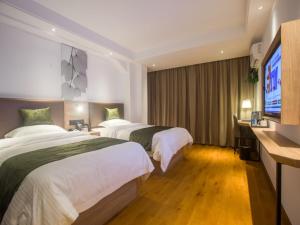 海口GreenTree Inn Haikou Haixiu Middle Road的酒店客房设有两张床和一台平面电视。