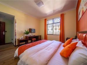 大理贝壳大理市大理古城南门酒店的一间卧室配有带橙色窗帘的大床