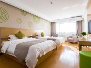 泗州格林豪泰宿州泗县汴河大道商务酒店的酒店客房,配有两张床和椅子