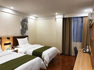 安顺格林豪泰黄果树瀑布景区智选酒店的酒店客房设有两张床和窗户。