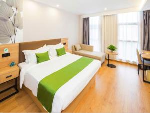 天津格林豪泰天津西青开发区人人乐广场智选酒店的酒店客房设有一张大床和一张书桌。