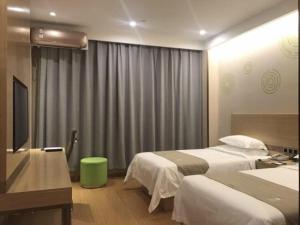 昔阳格林豪泰晋中市昔阳县汽车站商务酒店的酒店客房设有两张床和电视。