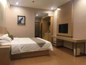 昔阳格林豪泰晋中市昔阳县汽车站商务酒店的一间卧室配有一张床、一张书桌和一台电视
