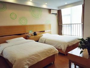 西宁格林豪泰青海省西宁市建国路火车站新千快捷酒店的酒店客房设有两张床和窗户。