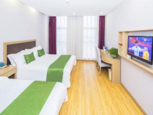 天津格林豪泰天津西青开发区人人乐广场智选酒店的酒店客房设有两张床和一台平面电视。