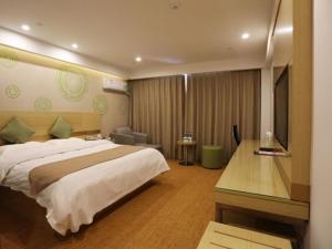 泗州格林豪泰宿州泗县汴河大道商务酒店的一间卧室配有一张床、一张书桌和一台电视