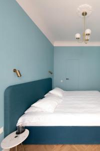 里加MIRO Rooms French - quiet chic, free private parking的蓝色卧室,配有床和桌子