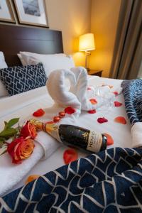考特尼Bayview Hotel的一瓶葡萄酒和毛巾,放在玫瑰床上
