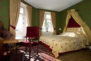 默勒库拉堡瑞典酒店的一间卧室配有一张床、一张桌子和一把椅子