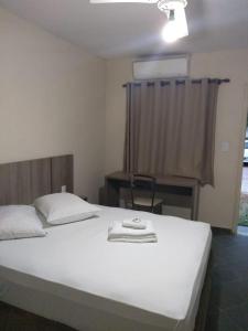 雅瓜里乌纳雅瓜里乌纳旅馆的卧室配有白色的床、书桌和窗户。