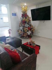 CaucasiaHOTEL TANIA的客厅配有圣诞树和沙发