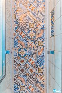 帕纳雷阿Hotel Eunymos的浴室铺有瓷砖地板,设有瓷砖墙。