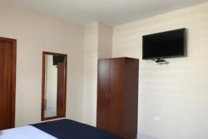 萨利纳斯Hotel Arena Blanca的卧室配有一张床和壁挂式平面电视。