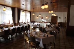 文斯托夫希铁诺酒店的用餐室配有桌椅和白色的桌布
