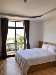 Xóm Mỹ CaLong Hồ Homestay的一间卧室设有一张大床和一个大窗户