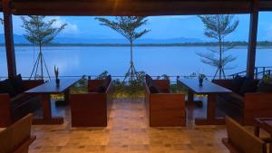 占巴塞The Riviera Champasak的餐厅设有桌椅,享有水景。