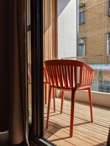 台南阡陌-頂加民宿的靠窗的阳台的红色椅子