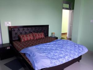 比尔瓦Mohinder & Mohindra Home Stay的一间卧室配有一张大床,提供蓝色毯子和红色枕头