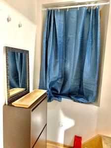 奥比松Logement Agréable récemment rénové à Aubusson的浴室设有镜子和蓝色窗帘