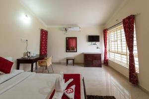 HalebīdKSTDC Hotel Mayura Shantala Halebeedu的一间卧室配有一张床、一张桌子和一张桌子