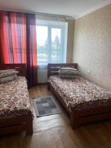 KhrystynivkaHotel Yuvileyny的一间卧室设有两张床,窗户配有窗帘