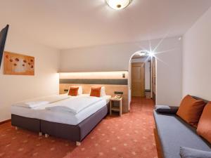 蒂罗尔-基希贝格里夫特酒店的酒店客房,配有床和沙发