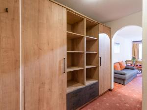 蒂罗尔-基希贝格里夫特酒店的客厅里一张大木柜,配有沙发